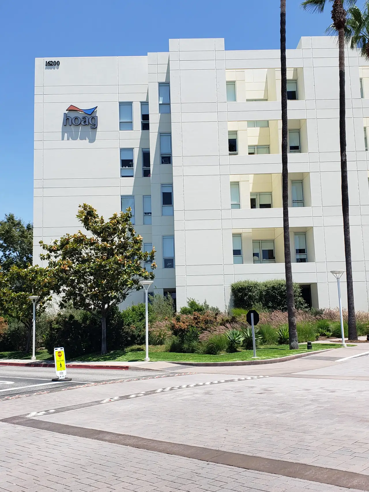 A tall white building with many windows on the side.