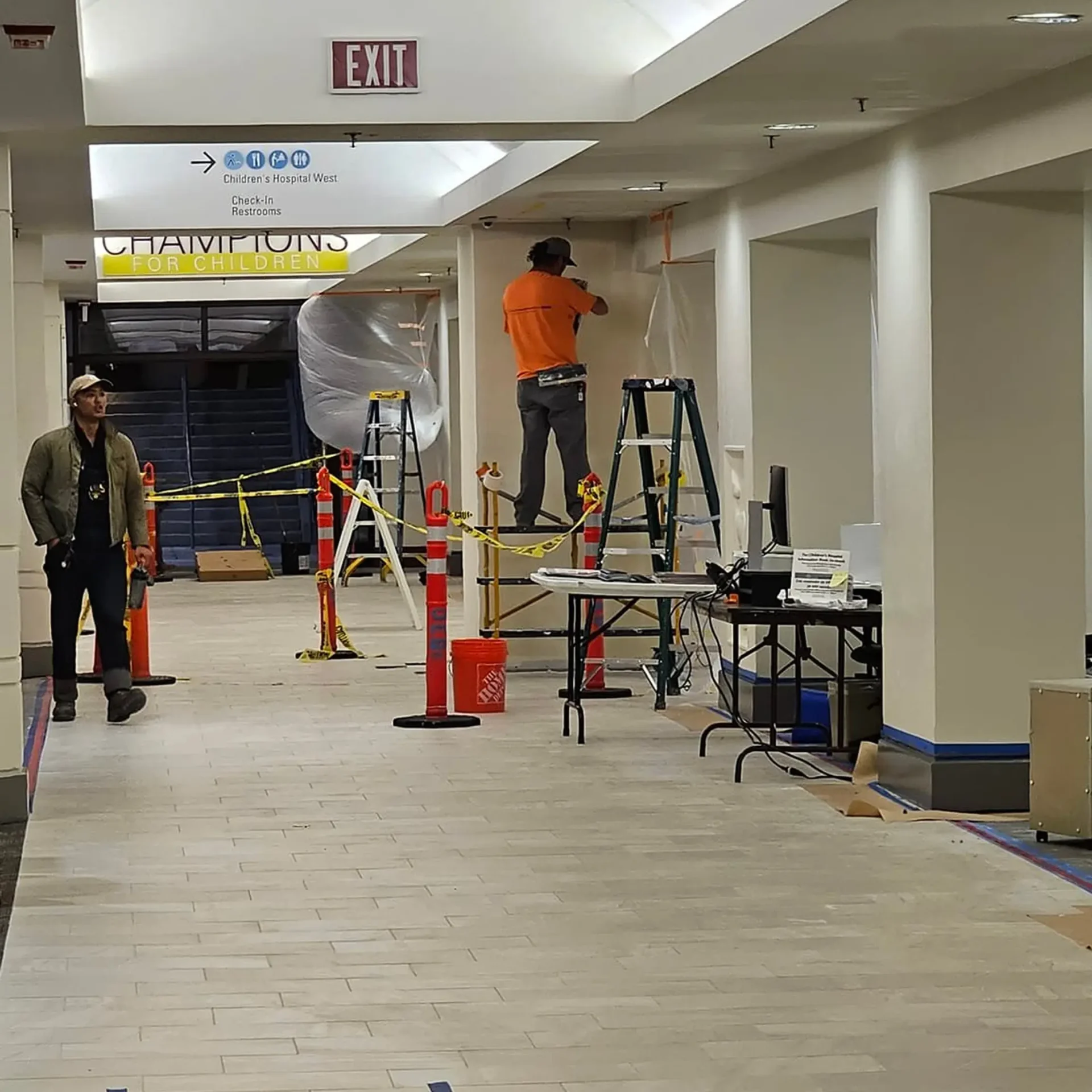 Workers measuring interior ceiling office.
